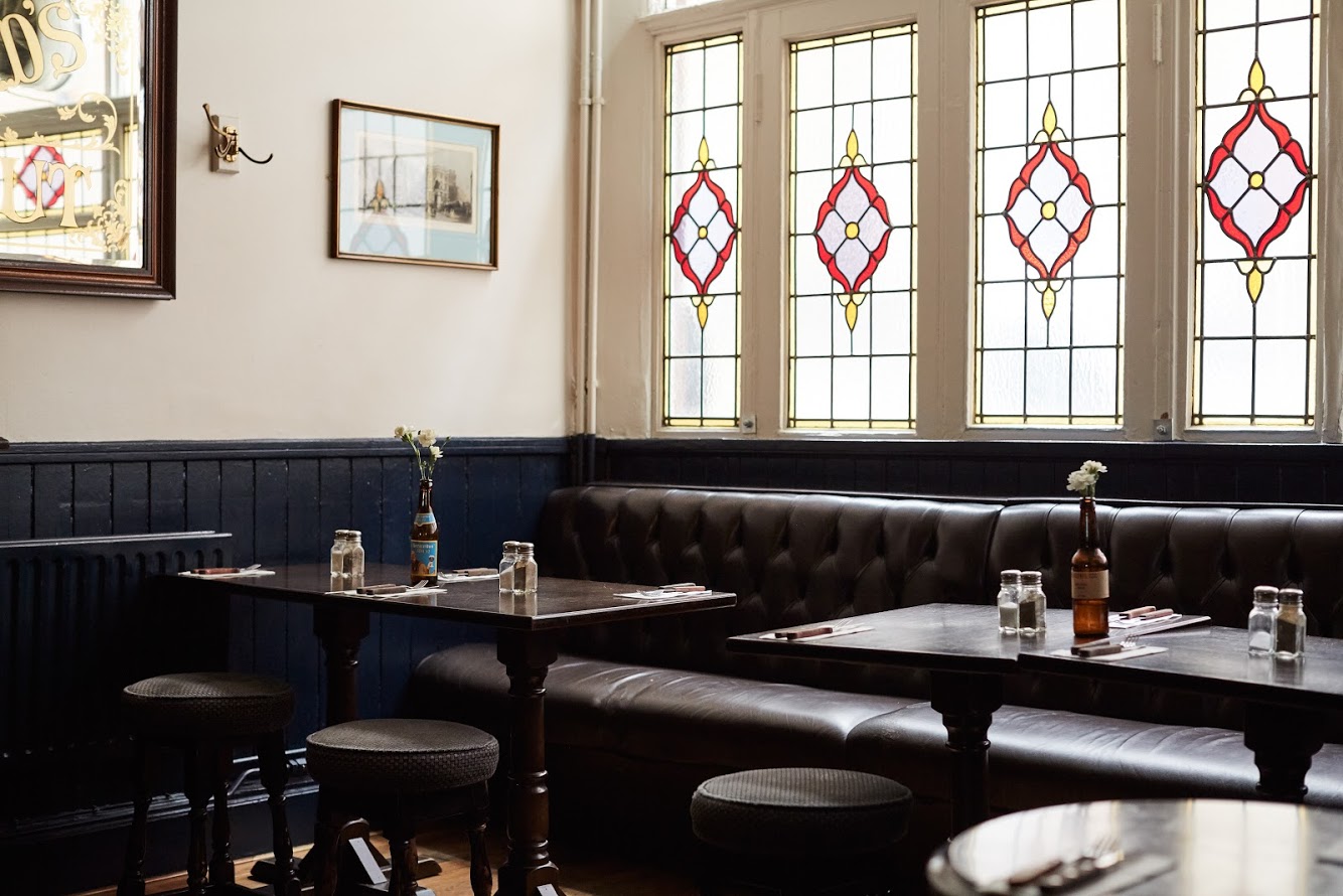 Leather banquettes under the stained-glass windows