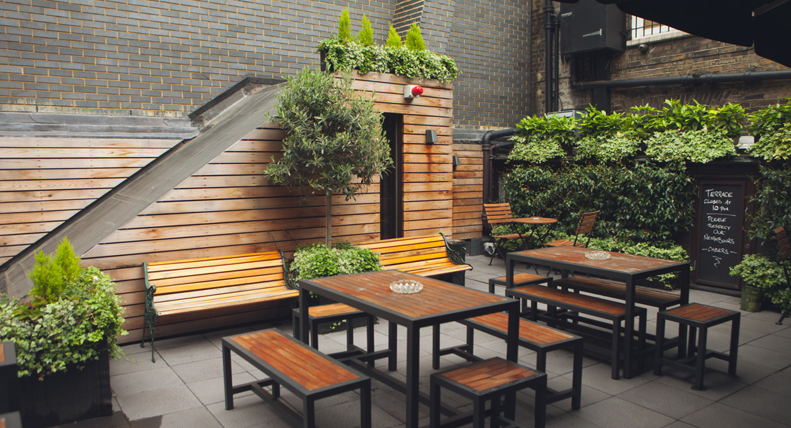 The planted roof terrace with timber benches and tables